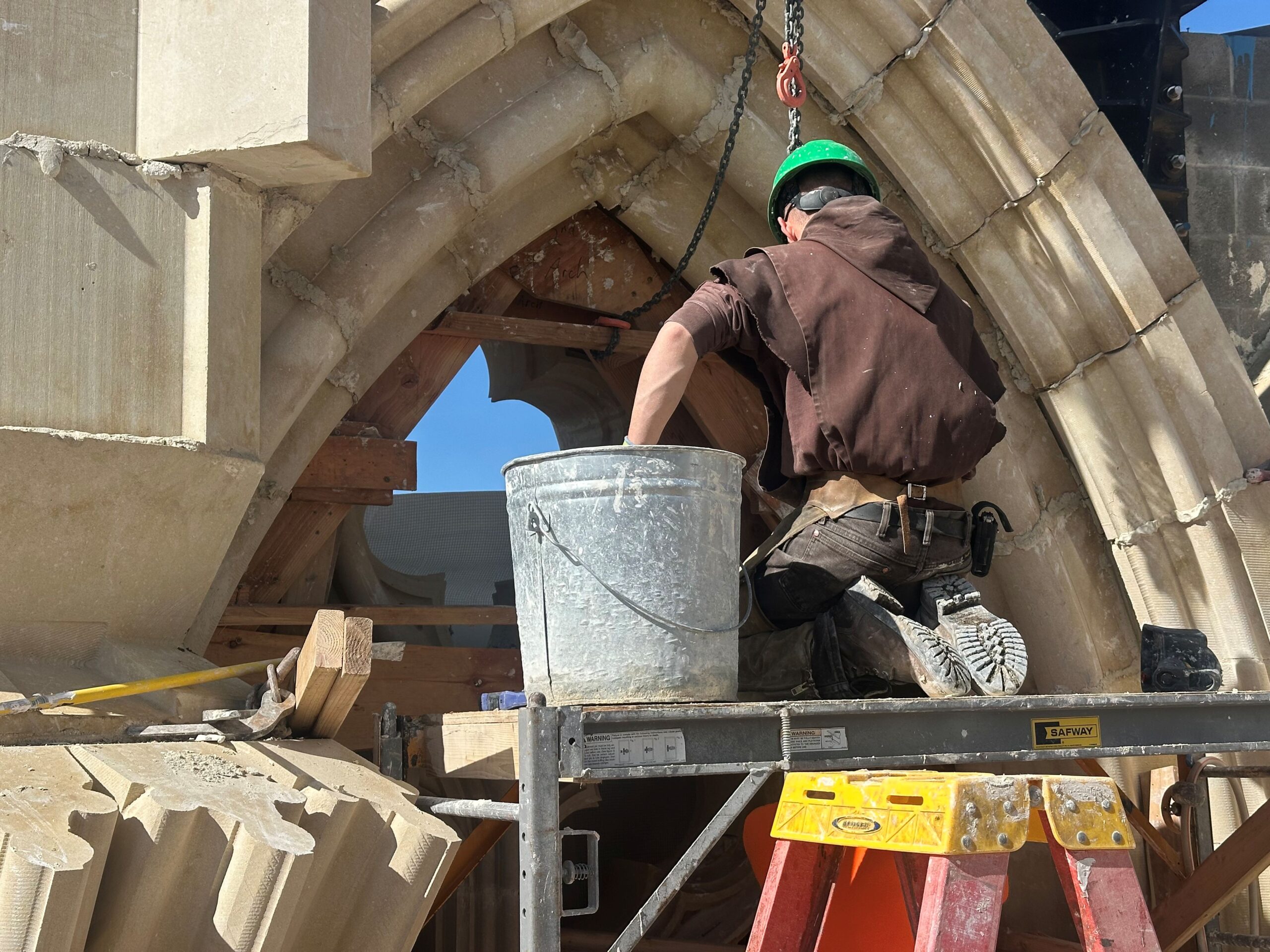 A monk builds a stone arch